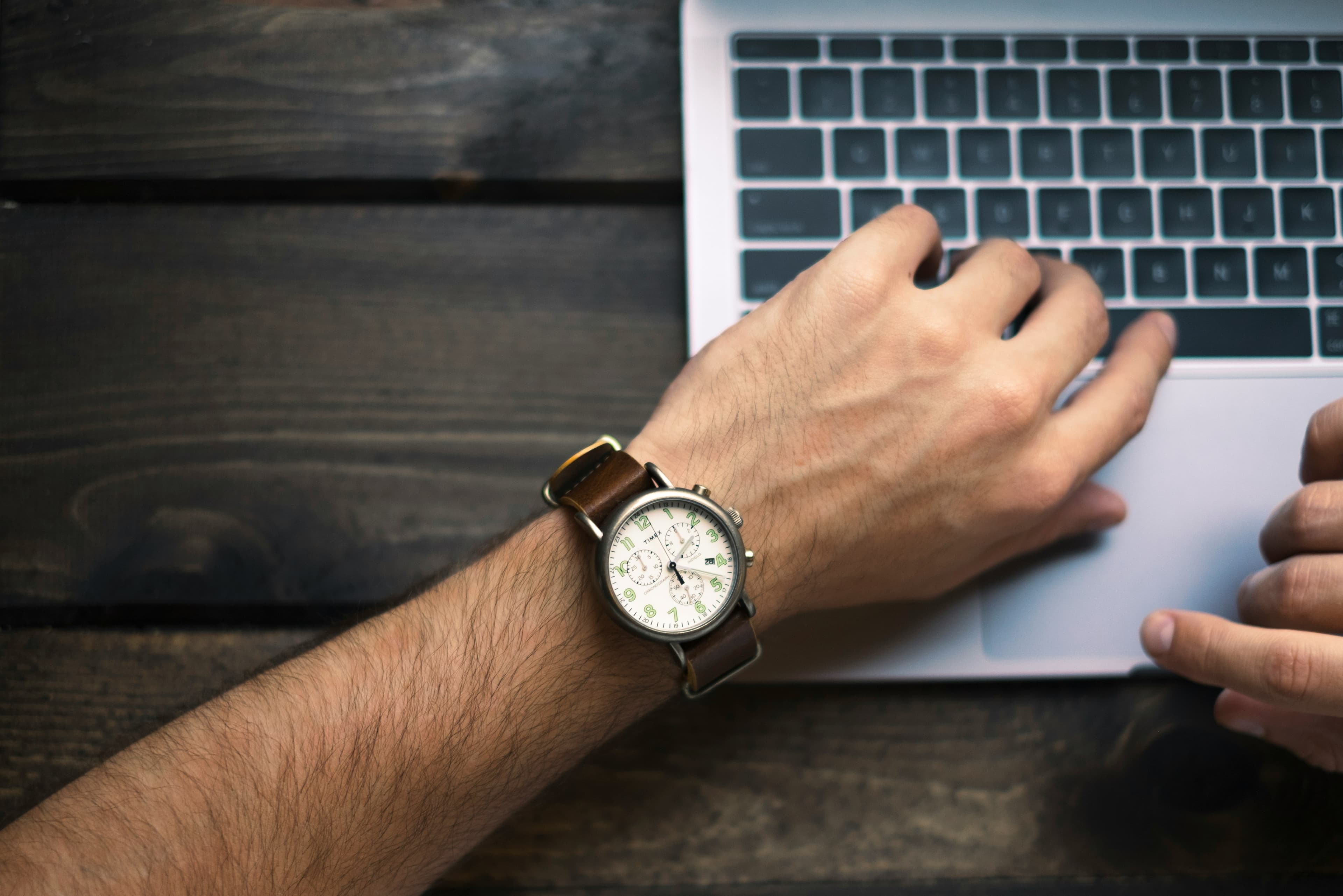 Man looking at watch using computer